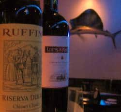 Bottles of wine and beer with a clam shell in the background at Uncle Vinnie's Clam Bar.